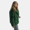 High Potential 2025 fur coat in striking green, adding a touch of drama.