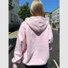 Light pink hoodie with ribbed cuffs and zipper.